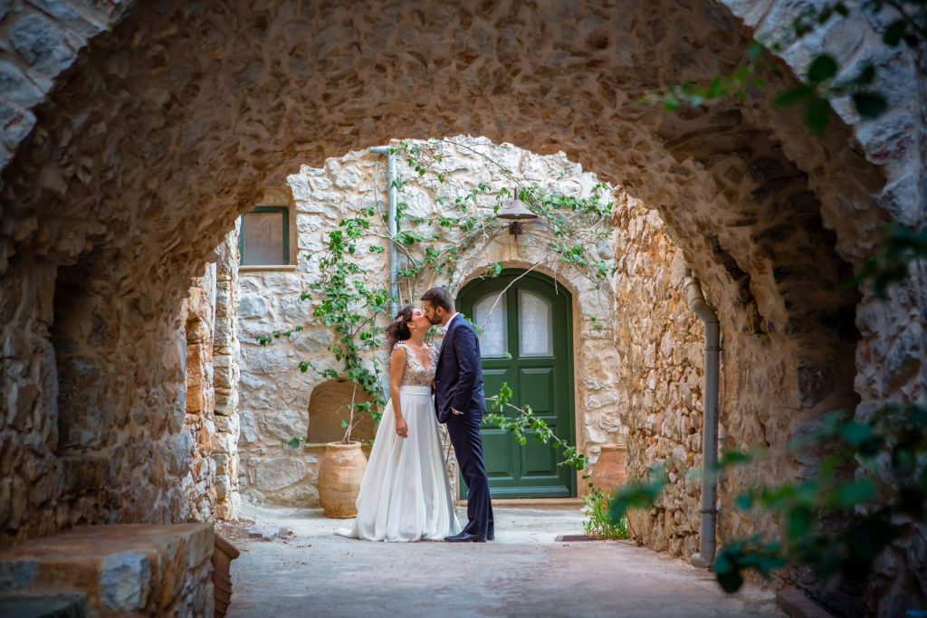 Bride and groom romantic portrait stone archway green door medieval village Mastichochoria Chios island Greece destination wedding photography