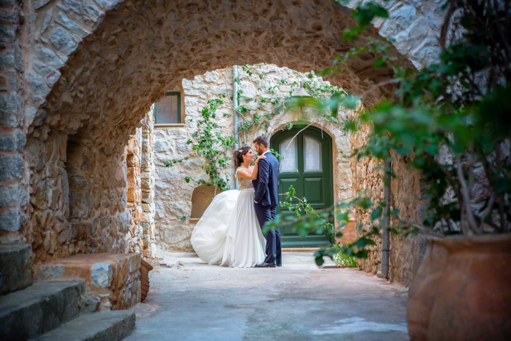 Bride and groom romantic portrait stone archway green door medieval village Mastichochoria Chios island Greece destination wedding photography