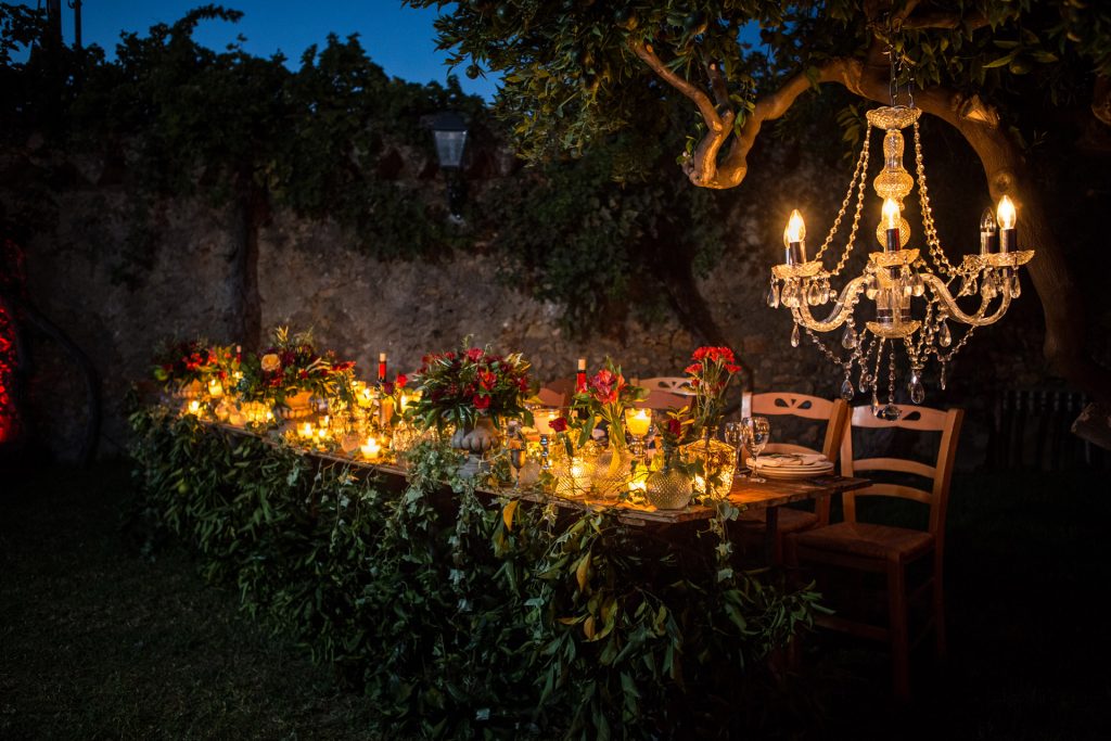 Elegant outdoor wedding reception table crystal chandelier candlelight floral centerpieces Metohi Istoria Chania Crete Greece destination wedding photography