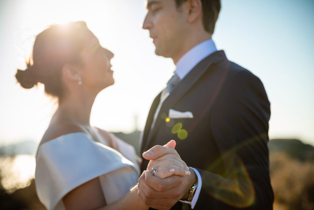 Bride and groom dramatic hilltop portrait dress flowing Cape Sounion Attica Greece coastal landscape destination wedding photography