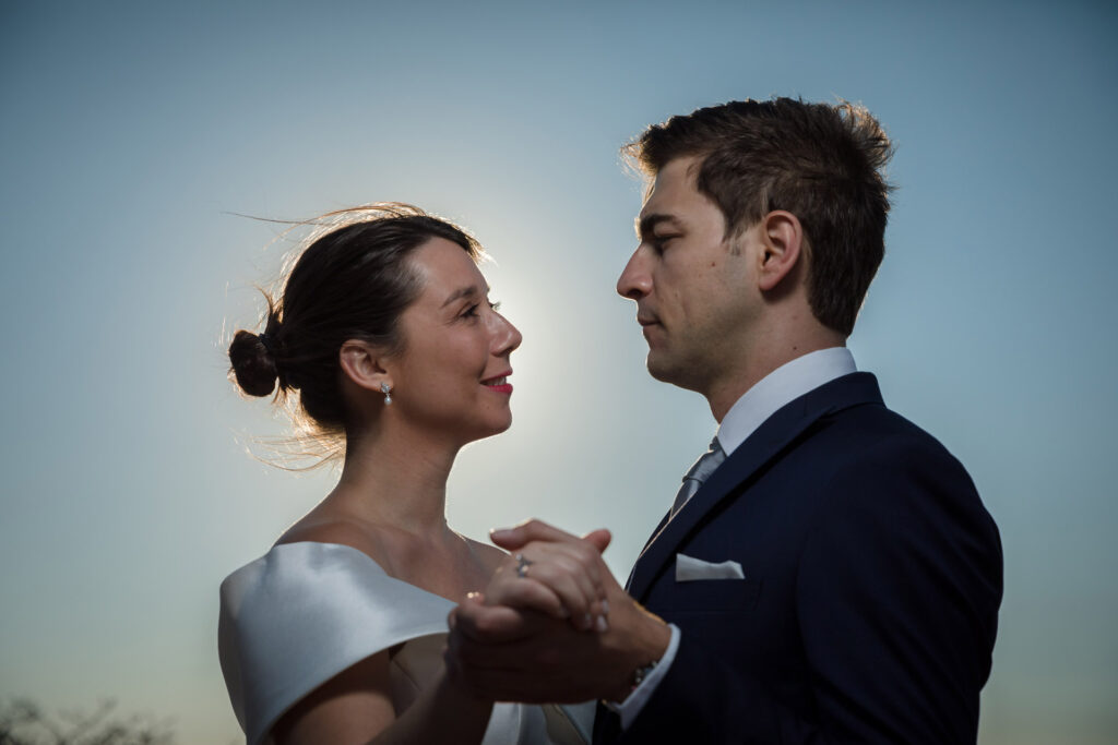 Bride and groom dramatic hilltop portrait dress flowing Cape Sounion Attica Greece coastal landscape destination wedding photography