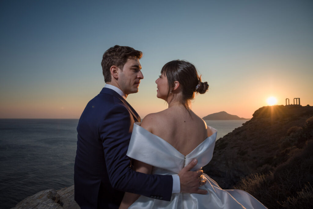 Bride and groom dancing sunset Temple of Poseidon Cape Sounion Greece ancient columns coastal landscape destination wedding photography