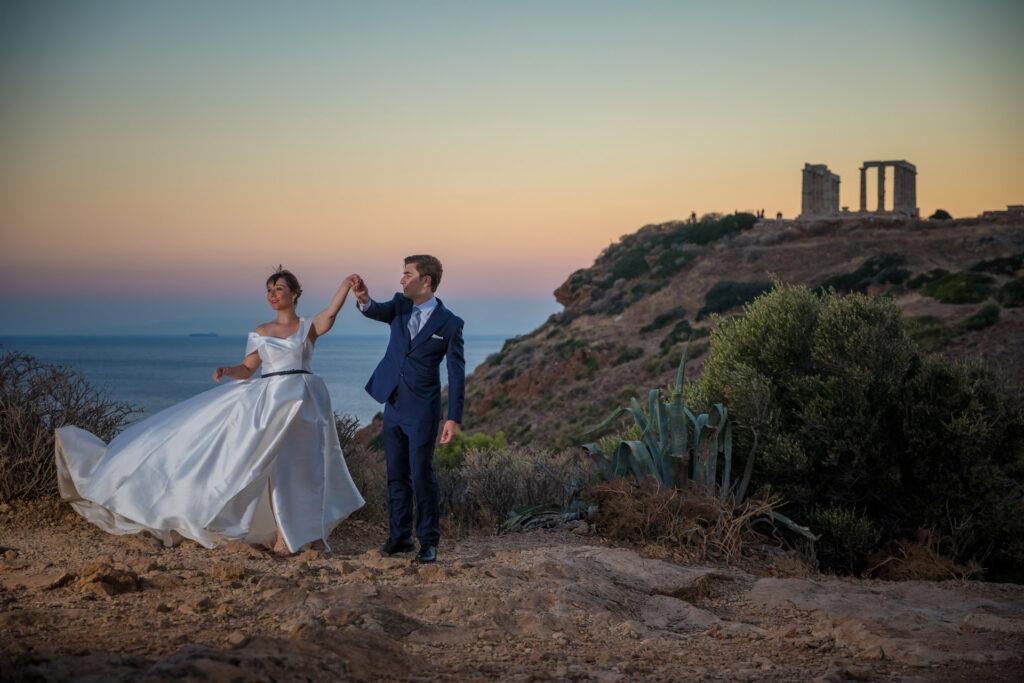 Bride and groom dancing sunset Temple of Poseidon Cape Sounion Greece ancient columns coastal landscape destination wedding photography